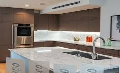 marble kitchen, amazed expression, unveiling new appliances, photorealistic, integrated into a modern living space with stylistic contemporary art, highly detailed, gleaming surfaces, extra crystal-clear details, deep taupe, mood lighting, shot with a 70mm lens.